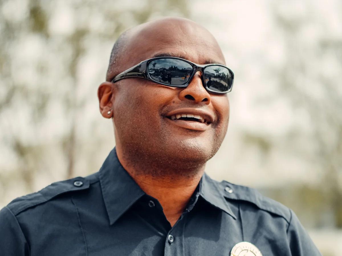 A uniformed private security guard on duty, radio clipped to his shirt